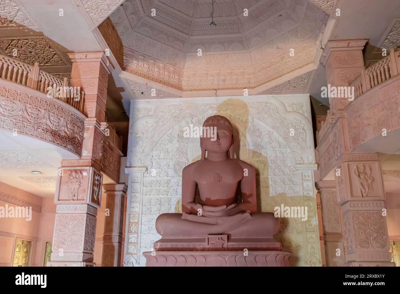 isolated red stone jain god holy statue in meditation from different angle image is taken at Shri Digamber Jain Gyanoday Tirth Kshetra, Nareli Jain Ma Stock Photo