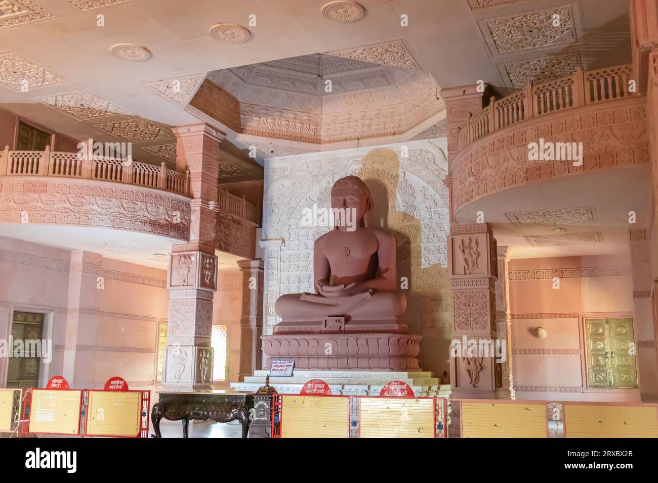 isolated red stone jain god holy statue in meditation from different angle image is taken at Shri Digamber Jain Gyanoday Tirth Kshetra, Nareli Jain Ma Stock Photo
