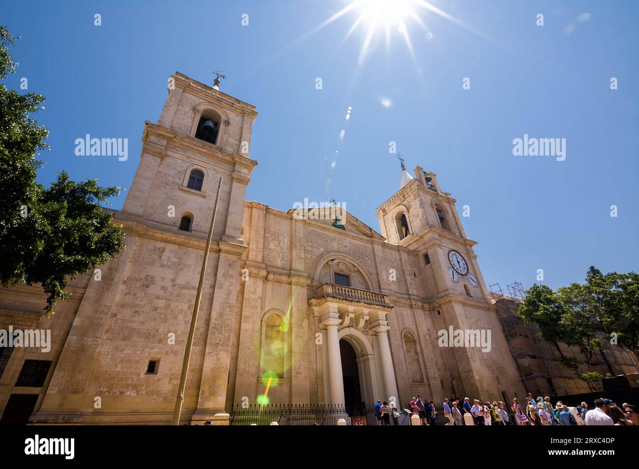 Valletta, Malta - 17 June 2023: Facade of Valletta Cathedral and tourists on a sunny day, Malta. Stock Photo