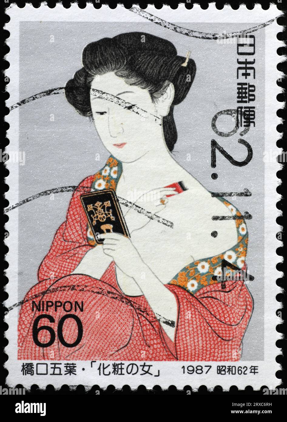 Japanese geisha with mirror on postage stamp Stock Photo