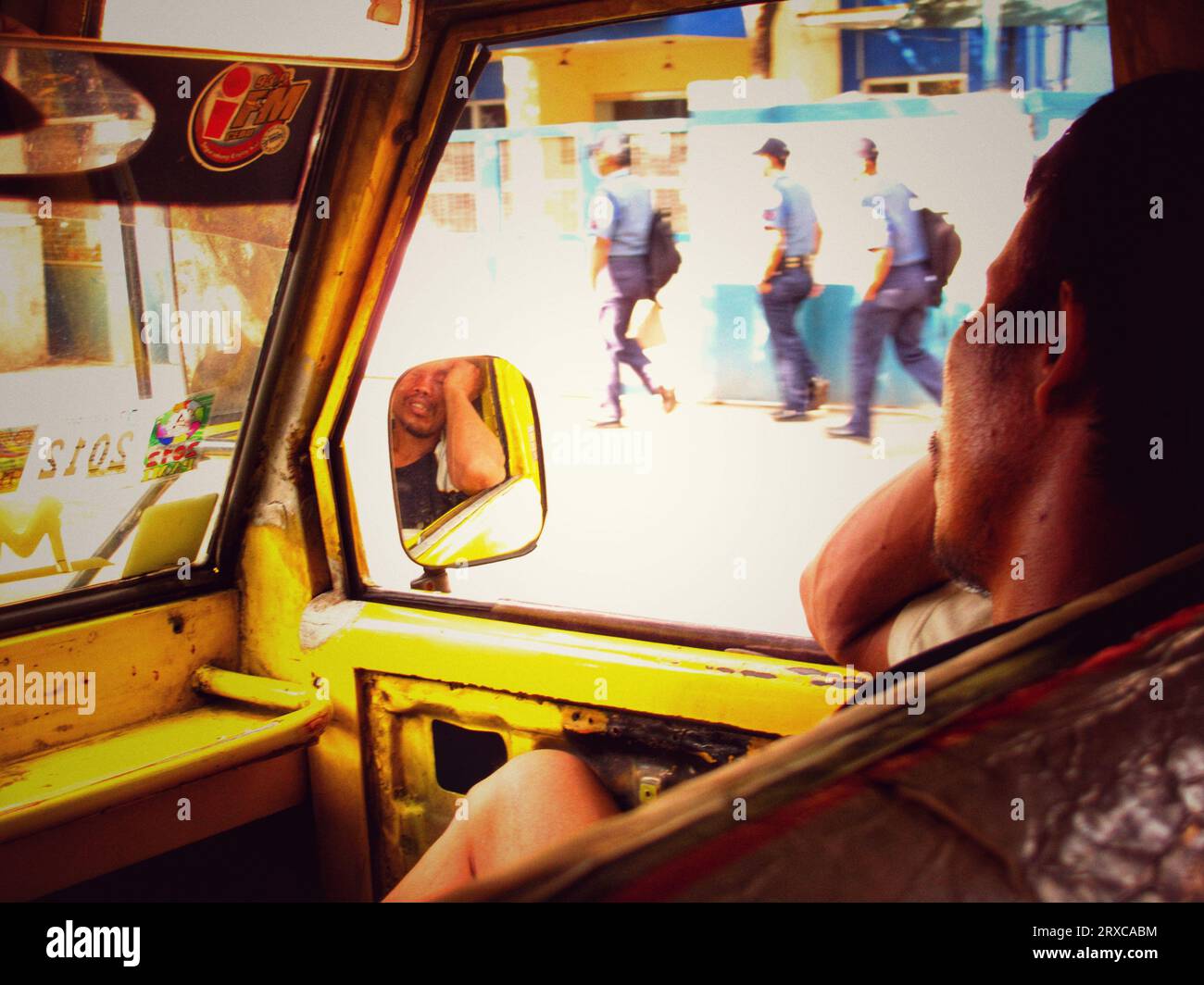Cebu city, Philippines - October 03, 2013: Exhausted passenger man sleeping on a front seat of jeepney vehicle during traffic hour in Cebu city. Stock Photo