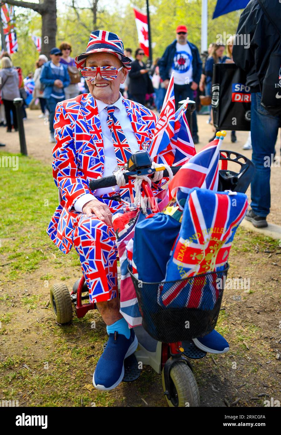 An OAP dressed completely in Union Jack clothing in a mobility scooter at the Mall London England celebrating the coronation of King Charles. Stock Photo