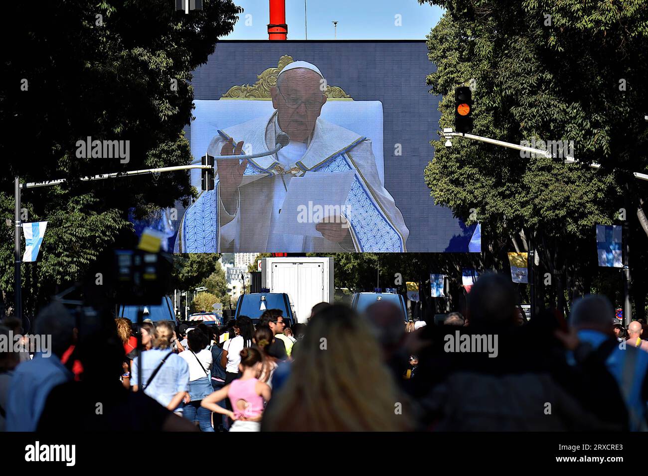People attend the mass given by Pope Francis at the Vélodrome on a super giant screen. Thousands of people came to see Pope Francis stroll in his “Papamobile” on Avenue du Prado, they attended the high mass on giant screens at the Vélodrome stadium. Stock Photo