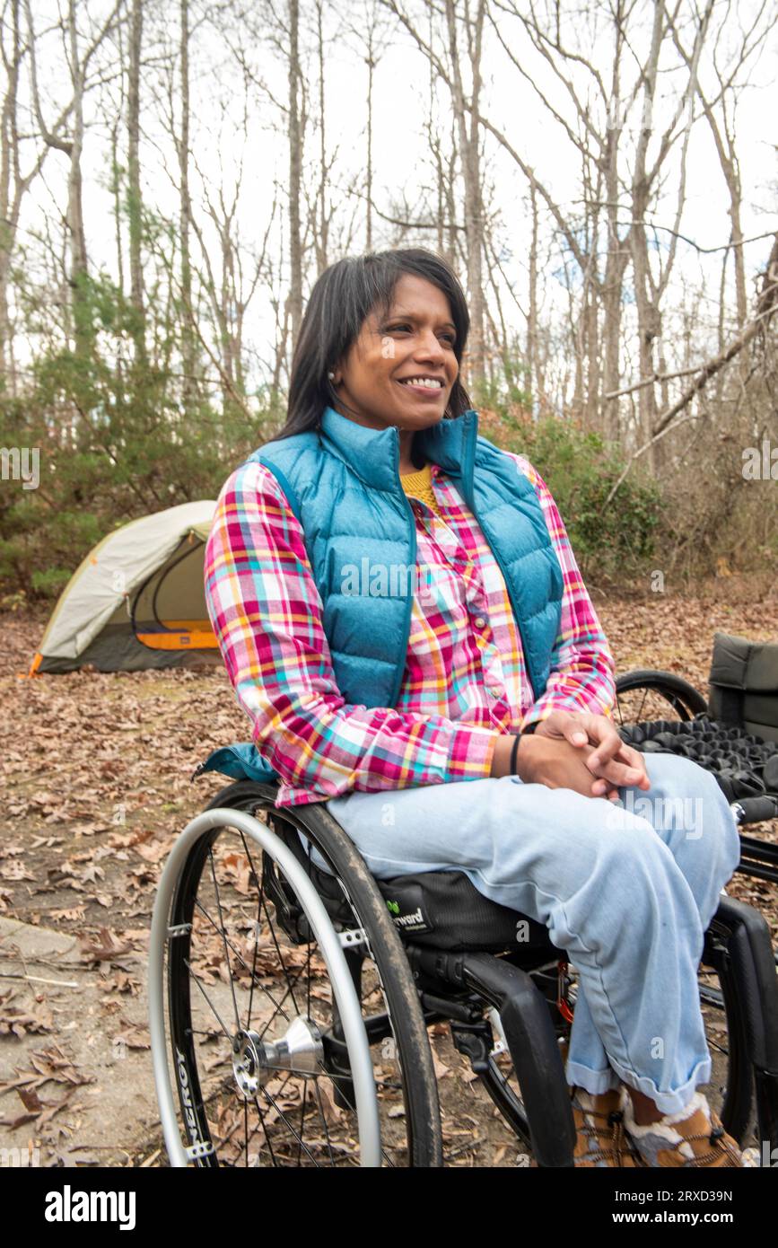 A disabled woman enjoys nature at a campsite. Being in a wheelchair doesn't stop her from enjoying the outdoors. Stock Photo