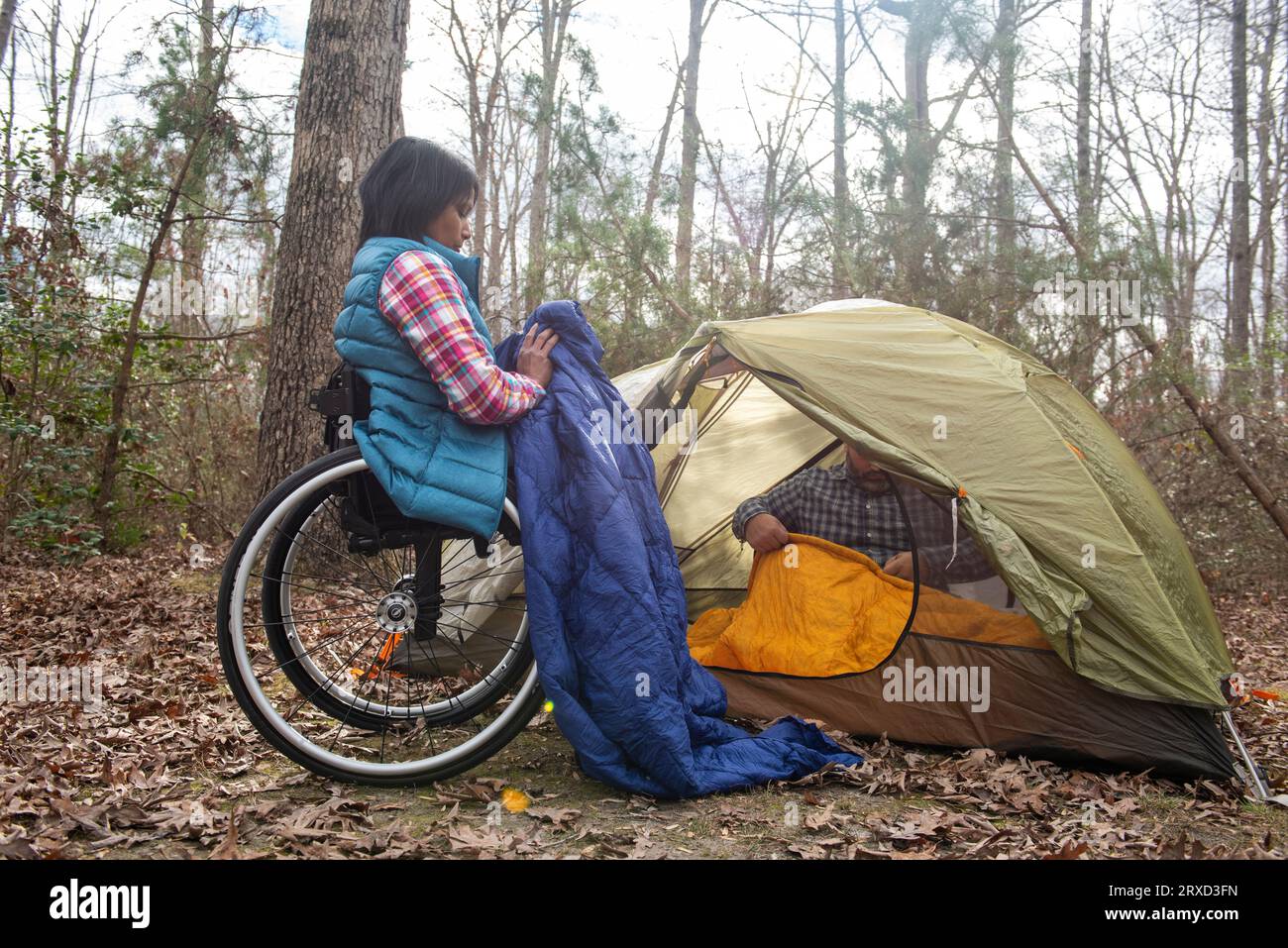 A man and woman set up a tent at a campsite. Both are disabled and love the outdoors, especially in the Autumn. Stock Photo