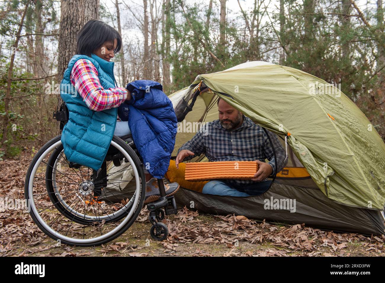 A man and woman set up a tent at a campsite. Both are disabled and love the outdoors, especially in the Autumn. Stock Photo