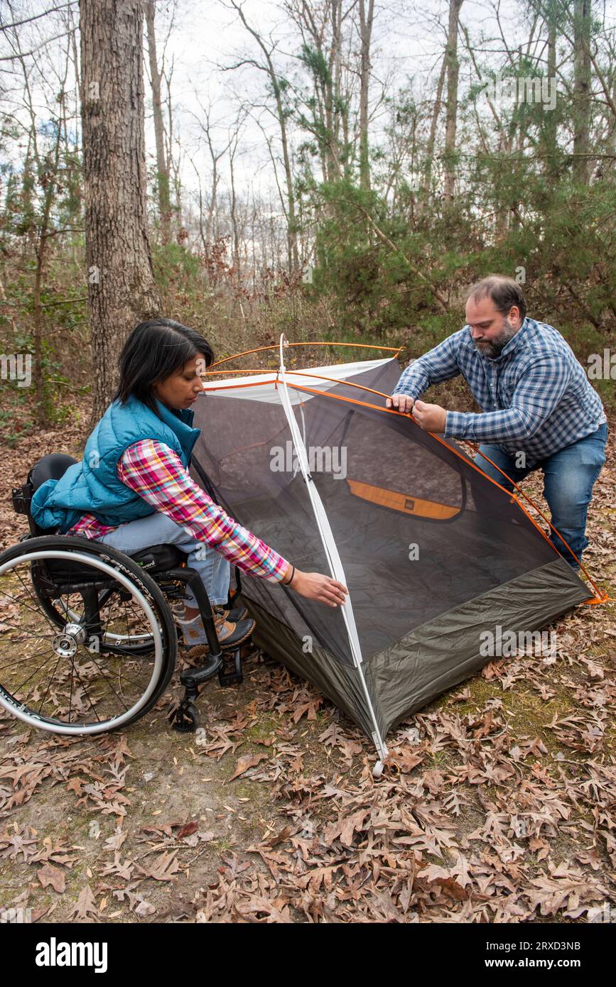 A man and woman set up a tent at a campsite. Both are disabled and love the outdoors, especially in the Autumn. Stock Photo