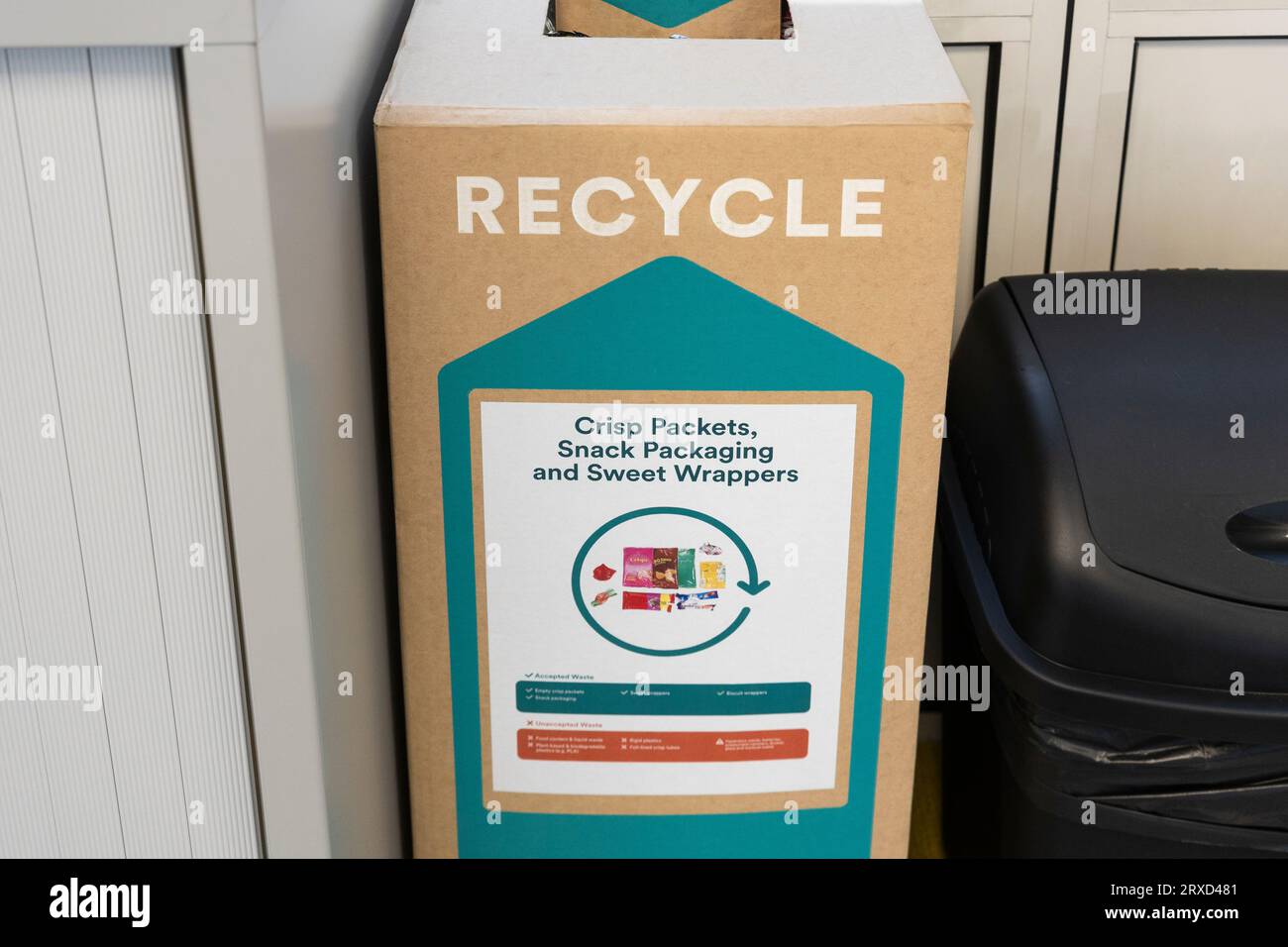 Crisp packet, snack packaging and sweet wrapper recycling box in a UK office. Concept: office recycling, food packaging recycling Stock Photo