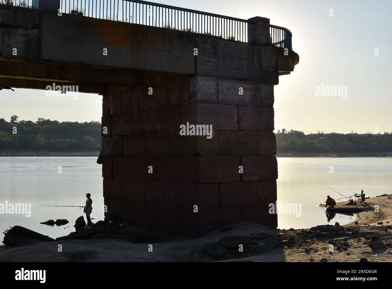 Zaporizhzhia, Ukraine. 18th Sep, 2023. Fishermen seen on the shoreline by the central pier as water in Dnipro river dropped more than 4 meters after the explosion of the Kakhovka dam in Zaporizhzhia. The commander of the Tavria group troops, Oleksandr Tarnavskyi (Ukraine), said that the Defence Forces had broken through the Russian defences in Verbove, Zaporizhzhia region. He adds that the main thing is not to lose the initiative that the Ukrainian army has now. (Credit Image: © Andriy Andriyenko/SOPA Images via ZUMA Press Wire) EDITORIAL USAGE ONLY! Not for Commercial USAGE! Stock Photo