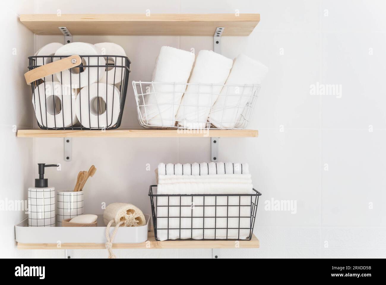 Beautiful white bathroom. Wooden shelves. Rolled towels, stacked towels ...