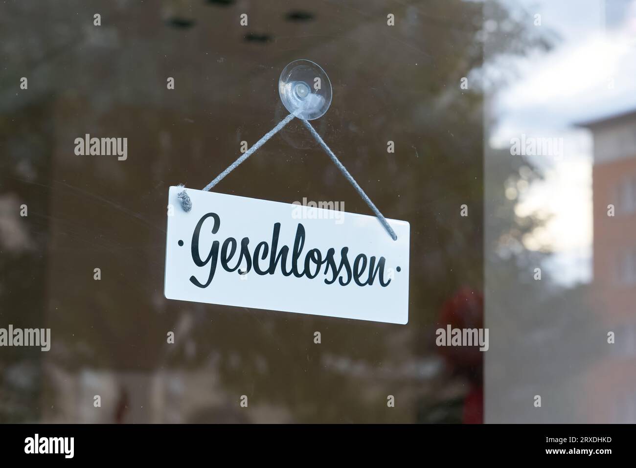 Sign with German inscription Geschlossen on a dirty shop window in the city center of Magdeburg in Germany. Translation: Closed Stock Photo
