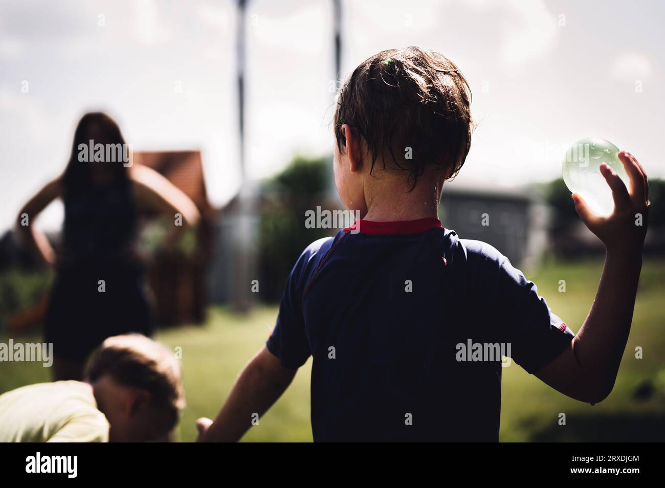 Young Caucasian boy taking aim to throw a water balloon Stock Photo Alamy