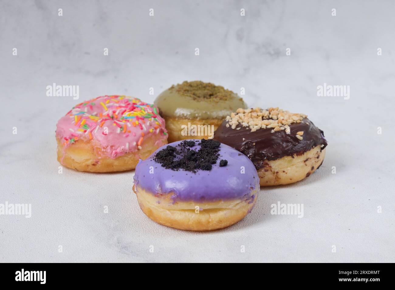 Delicious sweet donuts with different flavors on a table. Isolated image on white background Stock Photo