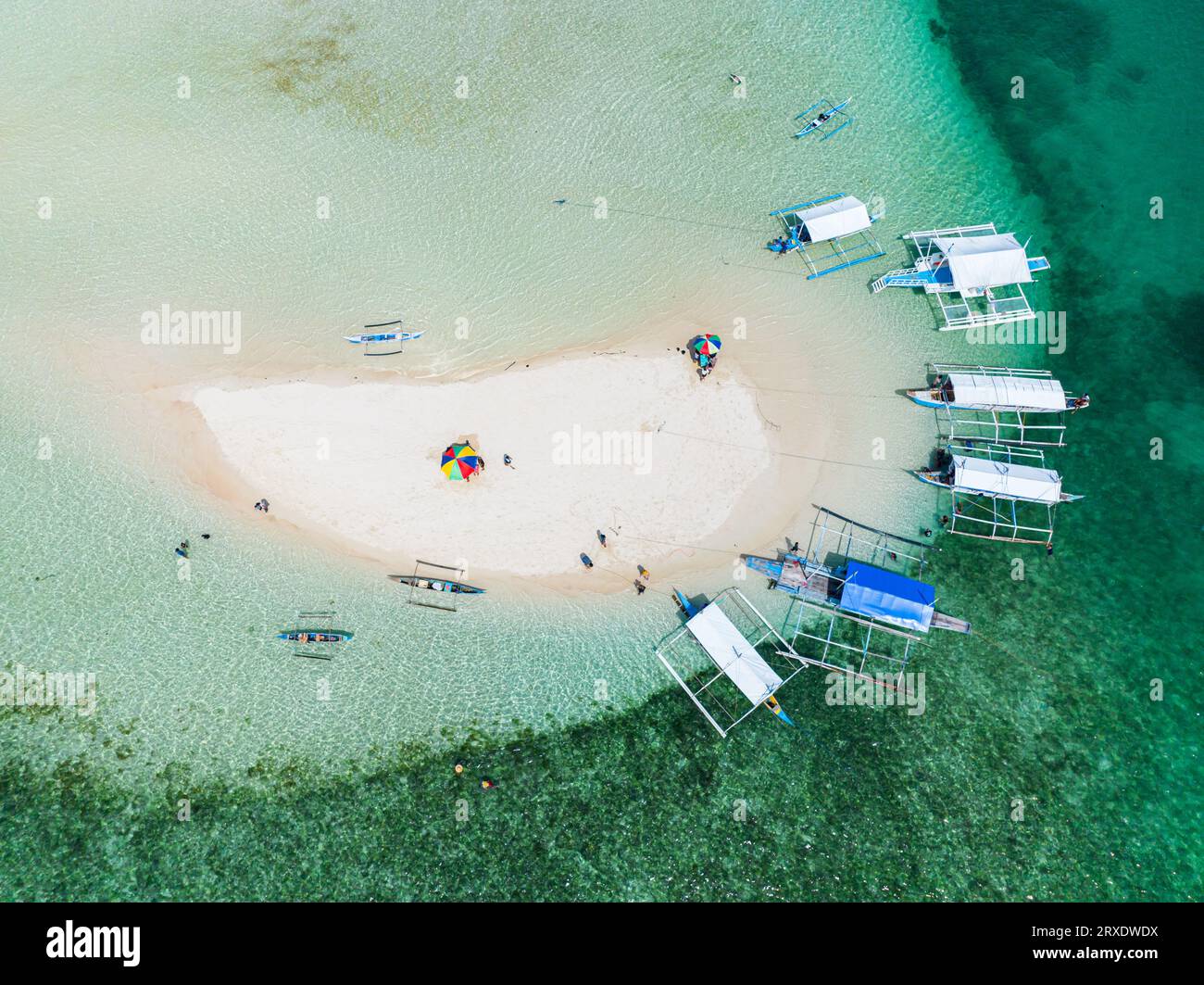 Drone view of boats on coastline of sandbar, turquoise water and colar reefs. Barobo, Surigao del Sur. Philippines. Stock Photo