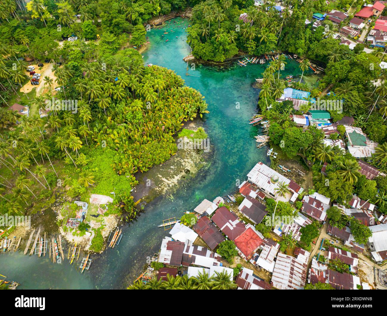 Clear turquoise water lagoon and fishing boats floating over the Bogac Cold spring. Surigao del Sur, Philippines. Stock Photo