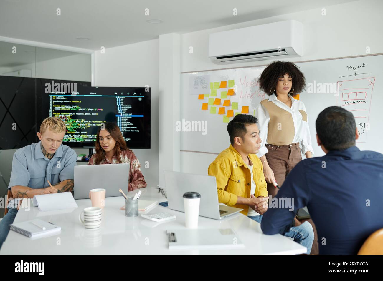Team working on new big project discussing programming code and mobile app interface Stock Photo