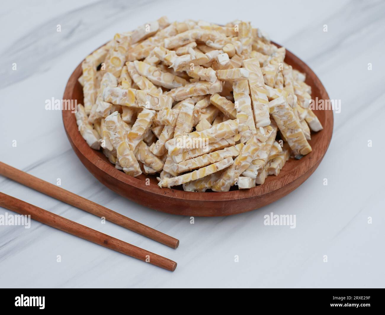 raw tempeh or tempe. Orek tempeh on a wooden plate. tempeh made from