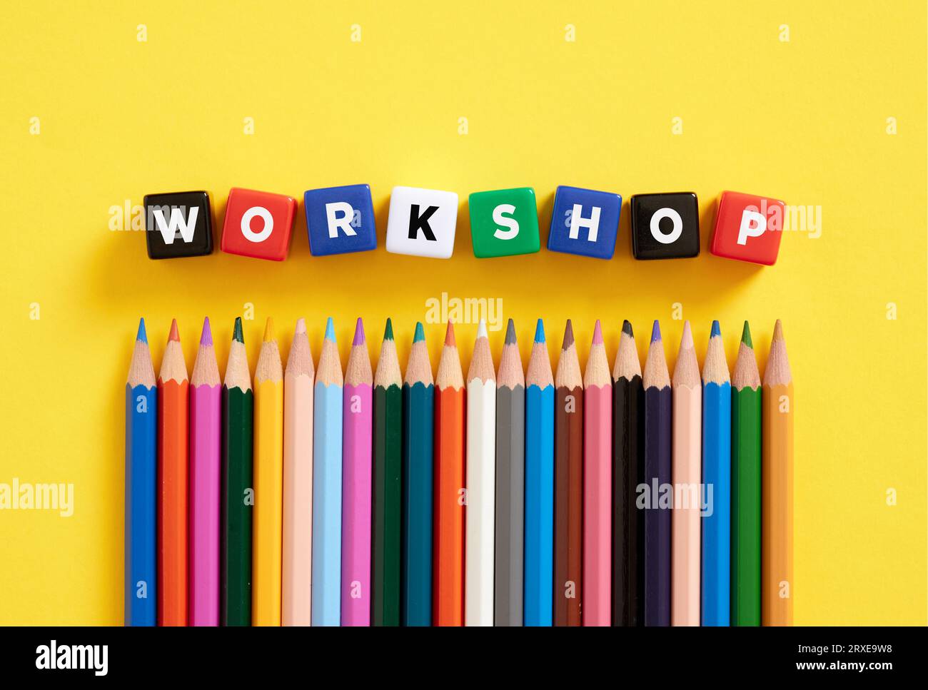 The word workshop on colorful cubes with crayons. Stock Photo