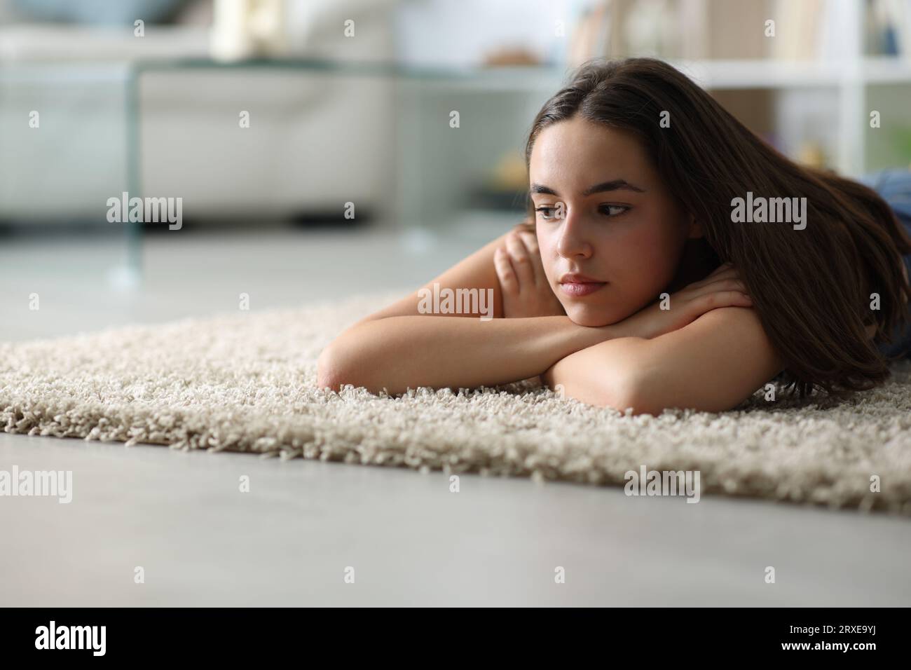 Sad woman lying on the floor at home in the night Stock Photo