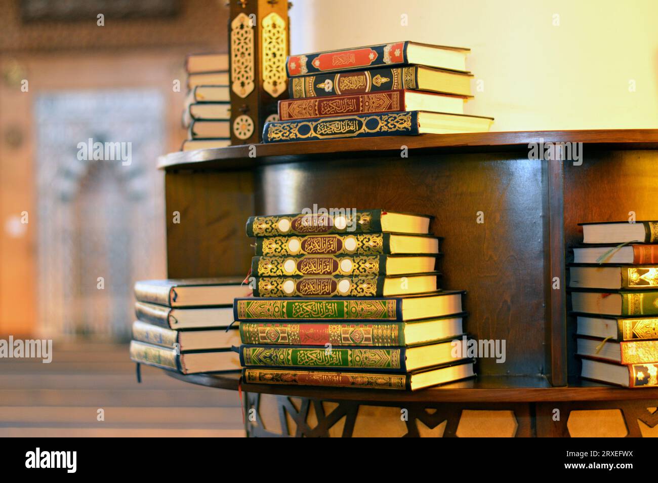 Holy Quran books in a row standing on a wooden shelf inside a mosque