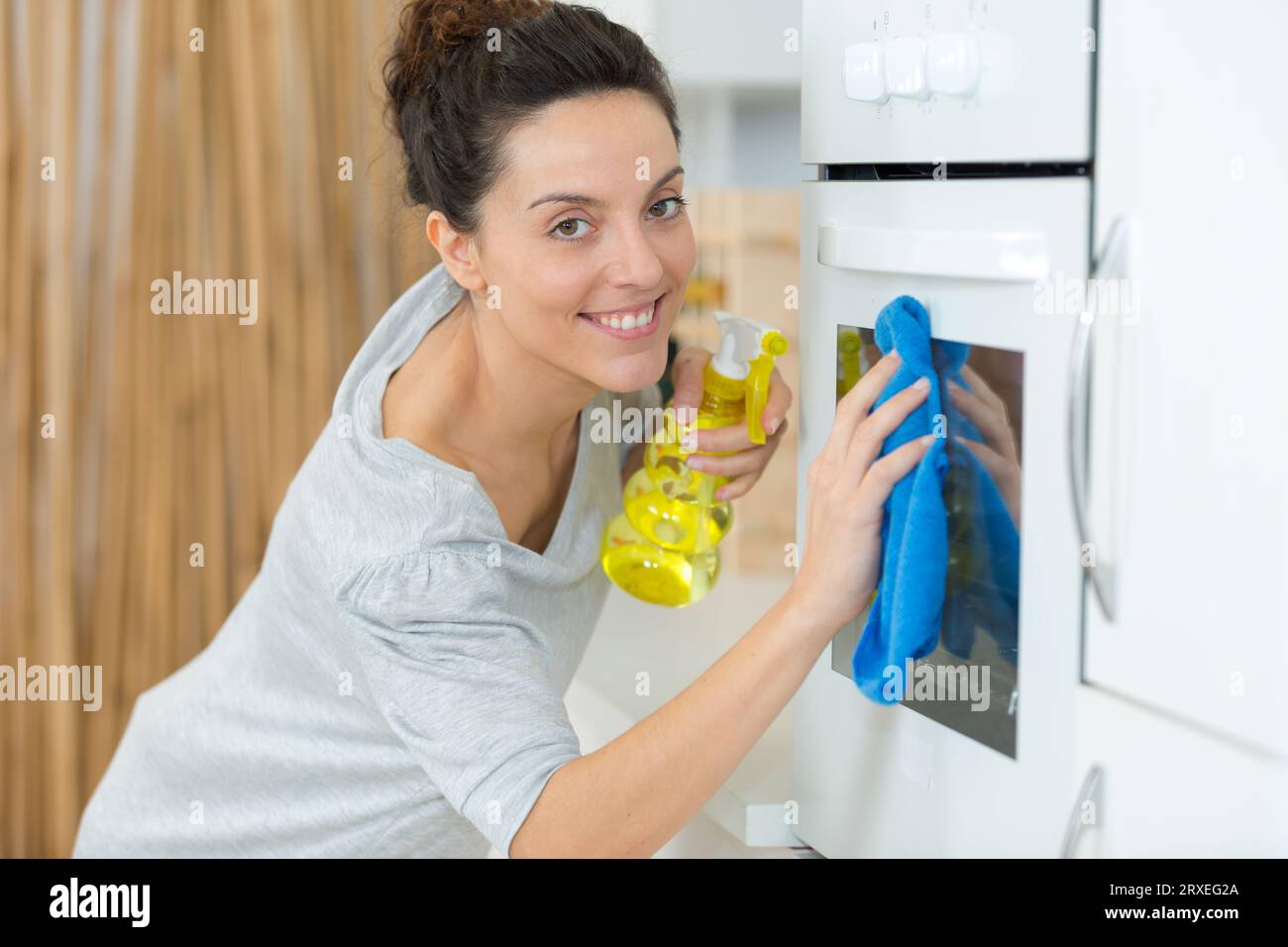 young woman cleaning the oven Stock Photo