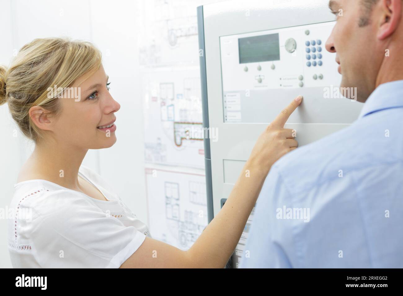 engineer training female apprentice on cnc machine Stock Photo