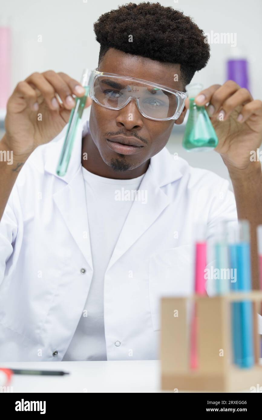 young man scientist using auto-pipette with flask Stock Photo