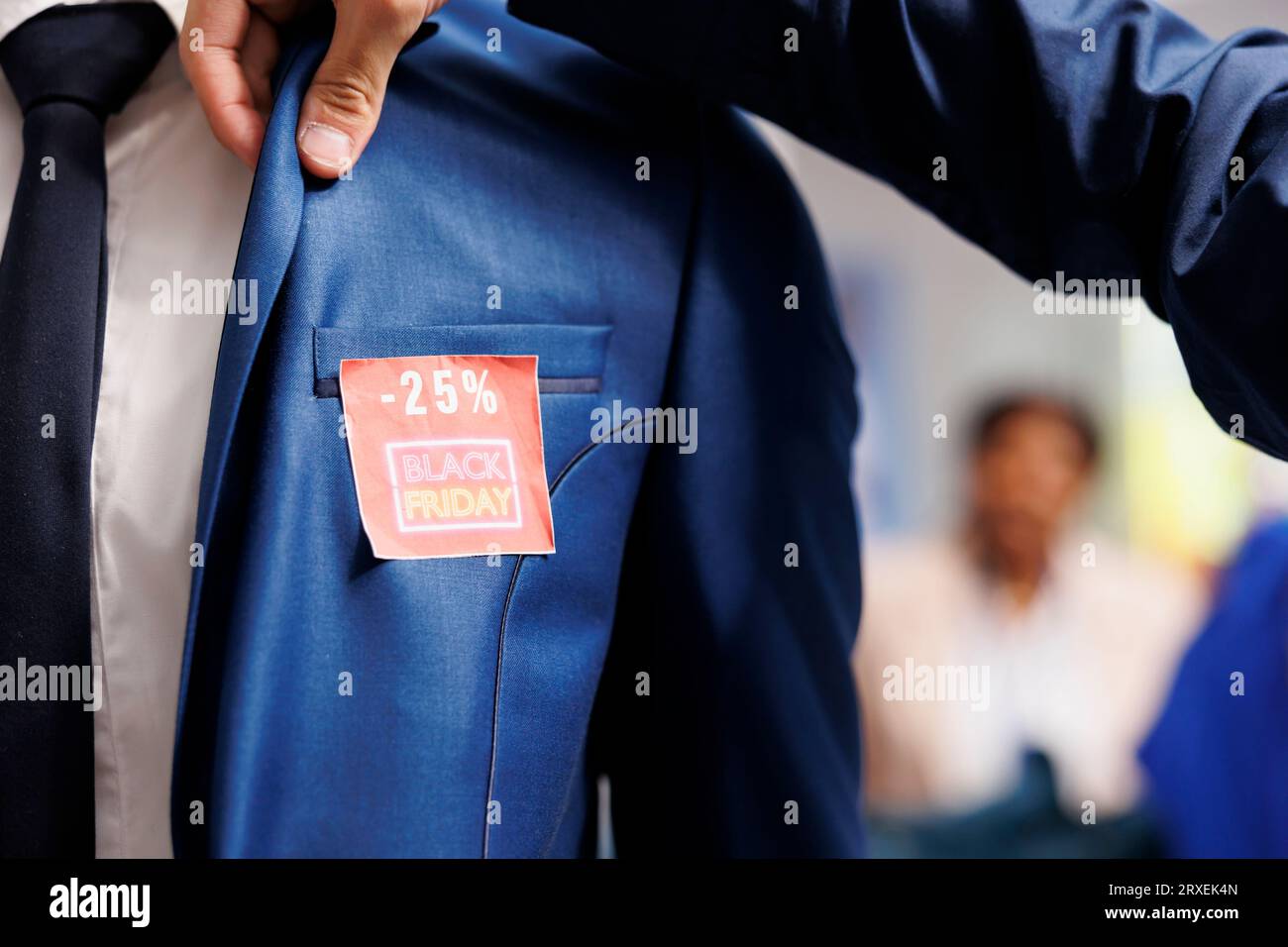 Male customer looking for clothing discount deals checking red sale price tag on suit while choosing clothes during Black Friday sales in shopping mall. Bargain hunting concept Stock Photo Alamy