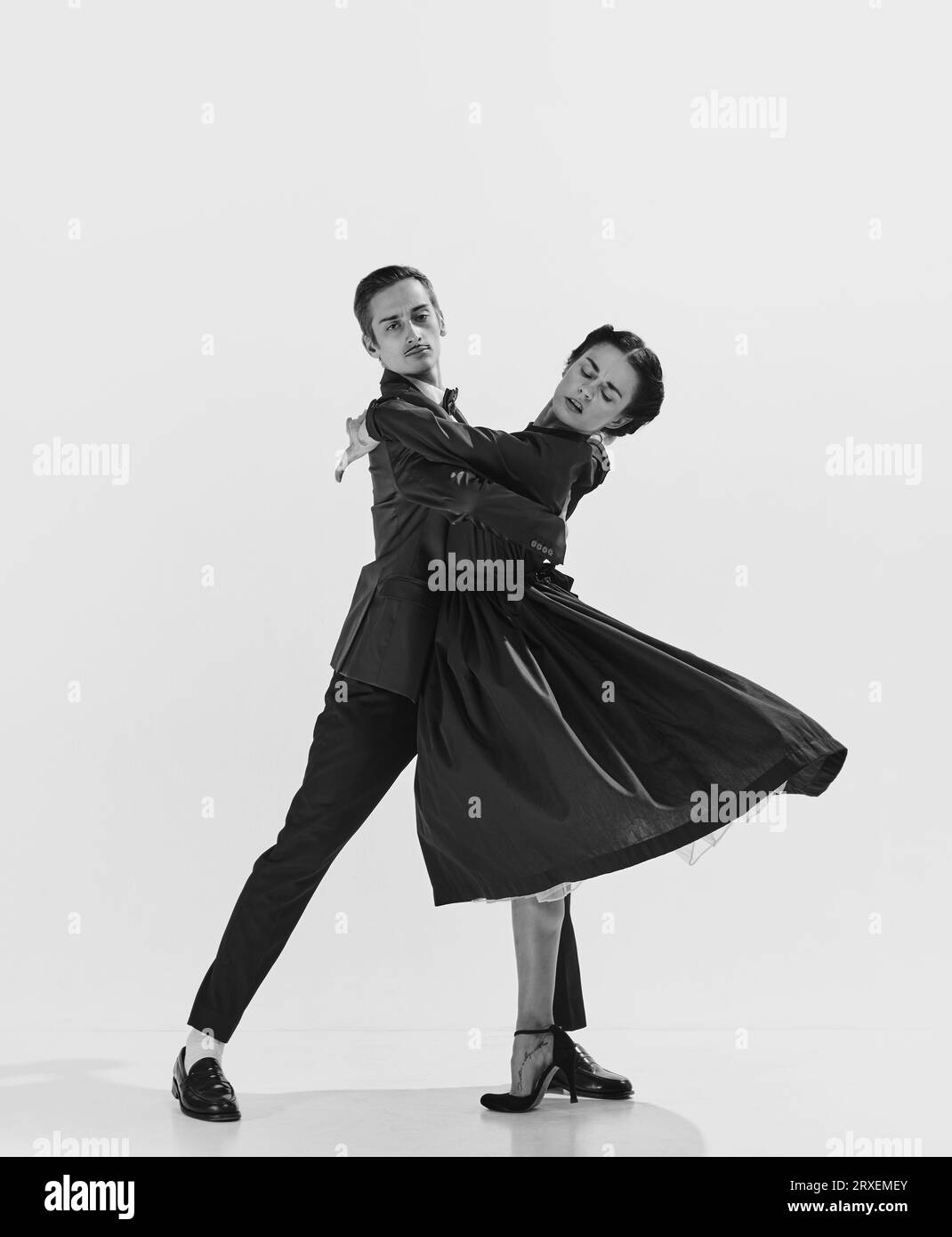 Elegance in movements. Black and white. Beautiful couple, man and woman in stylish clothes dancing Stock Photo