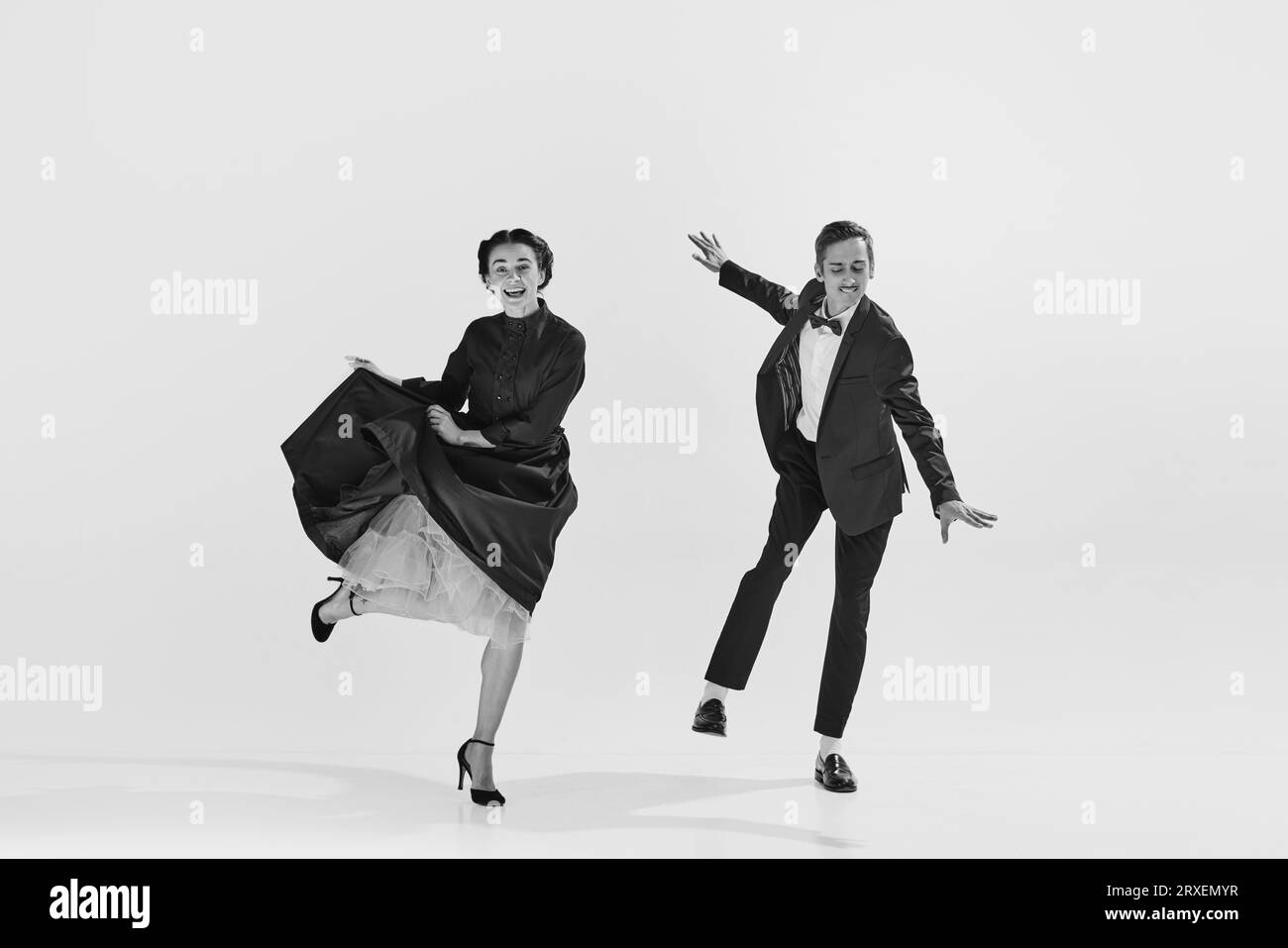 Black and white. Happy, positive, smiling young people, man and woman in elegant clothes dancing lindy hop Stock Photo