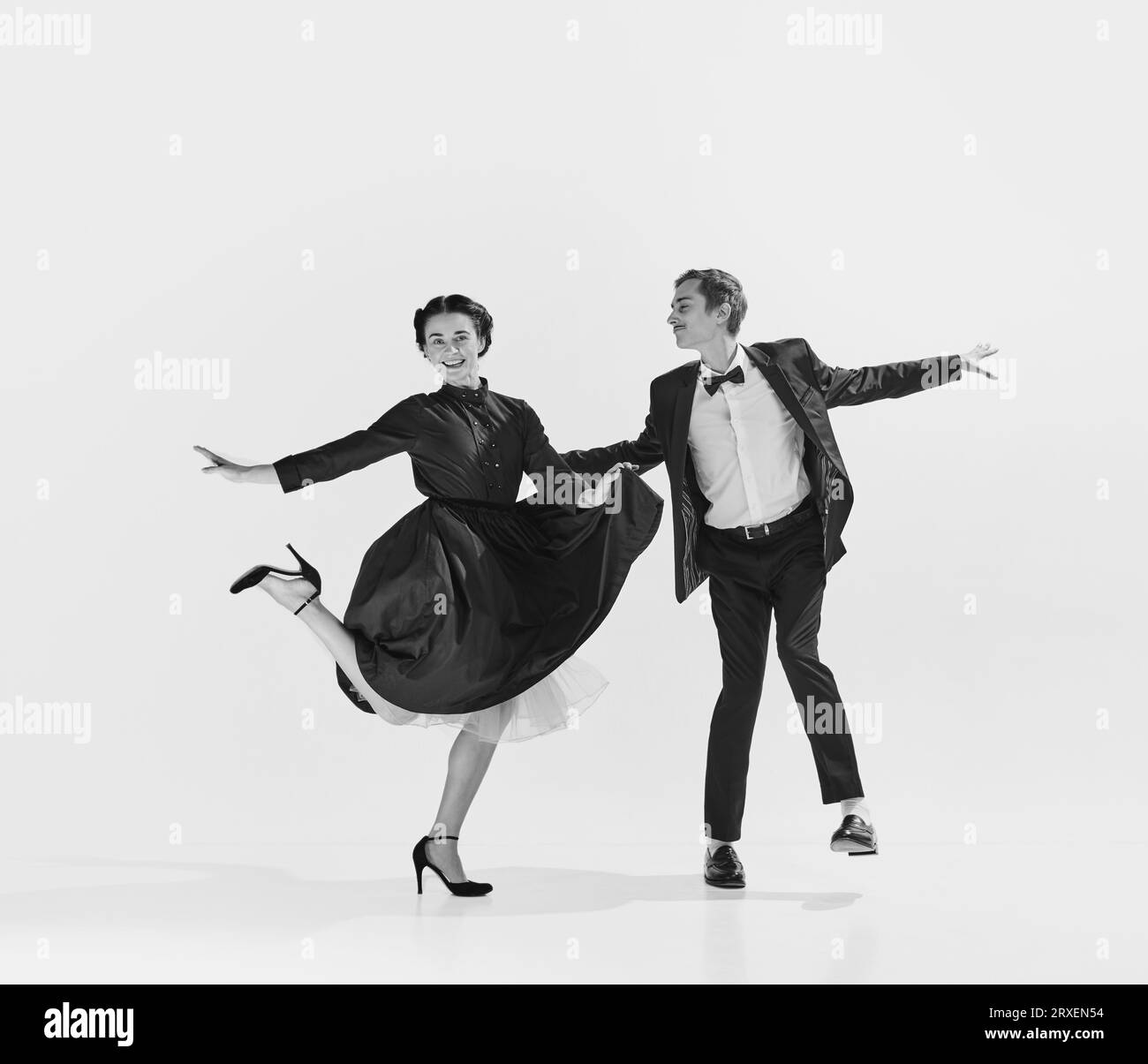 Black and white. Happy, positive, smiling young people, man and woman in elegant clothes dancing lindy hop Stock Photo