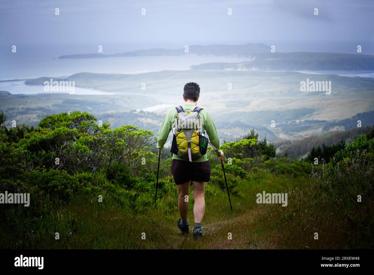 Rear view of a female hiker descending on a trail Stock Photo - Alamy