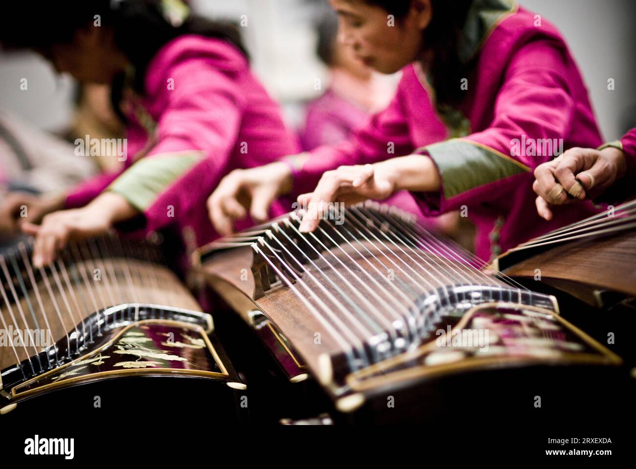 A group of GuZheng players using their fingers to control the pitch and vibrato of each note