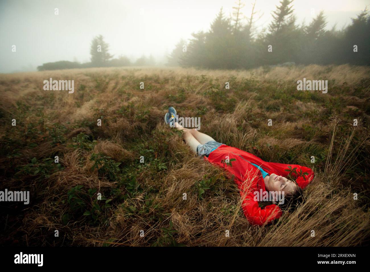 Man relaxes in foggy field Stock Photo