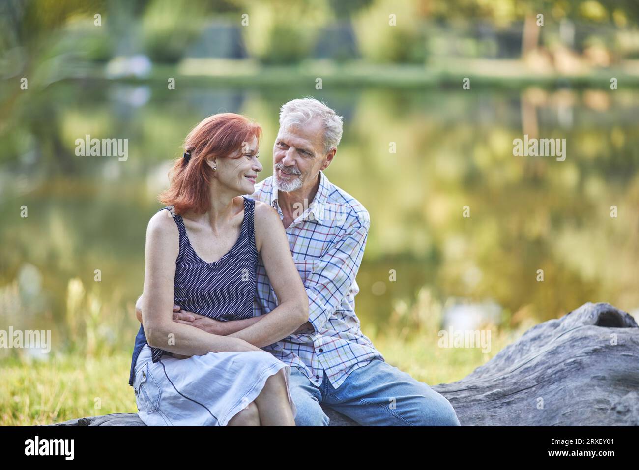 senior man and woman talking on the lake shore Stock Photo