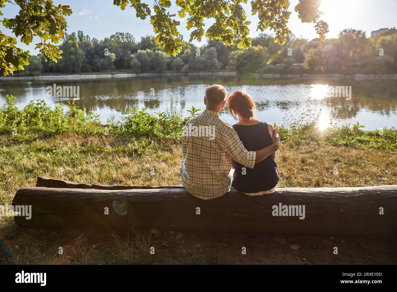 senior couple sitting and looking at the lake Stock Photo