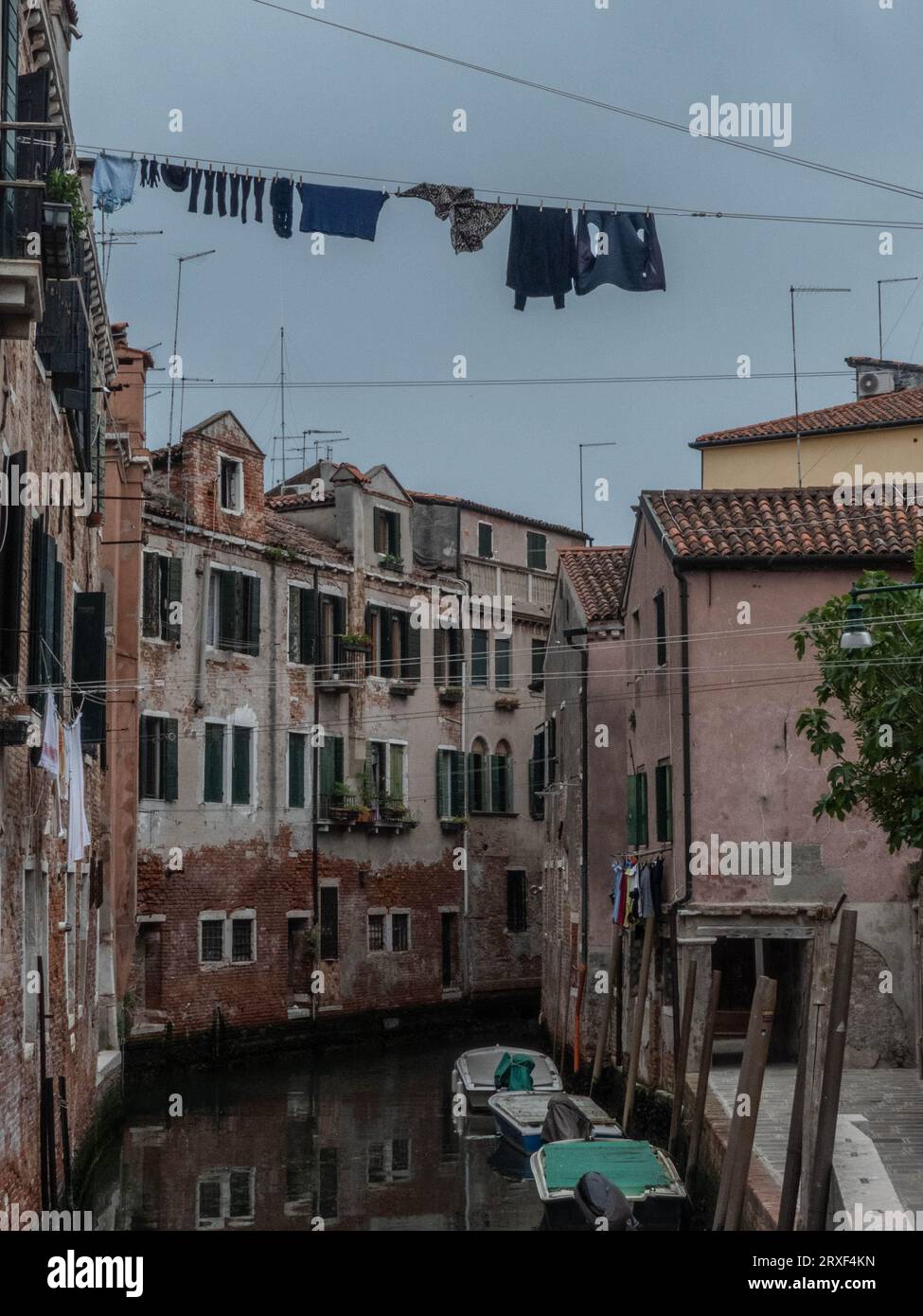 Un tranquillo momento a Venezia: case veneziane che si affacciano su un pittoresco canale, con i panni stesi ad asciugare. Stock Photo
