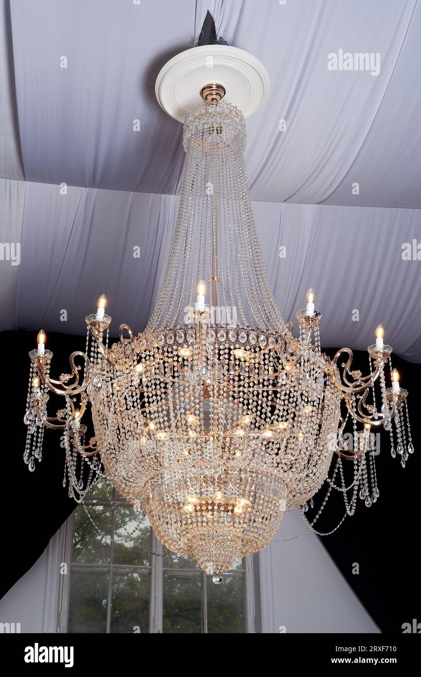 Heavy crystal chandelier with a ceiling decorated with fabrics. Palace