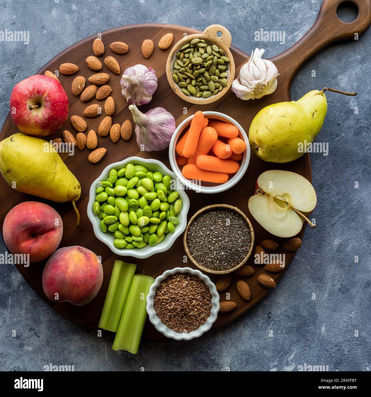 A round wooden board topped with healthy whole foods. Stock Photo
