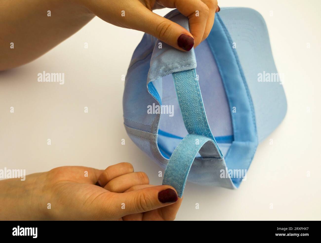 Cap in hands. velcro closeup. Determination of the size of a baseball
