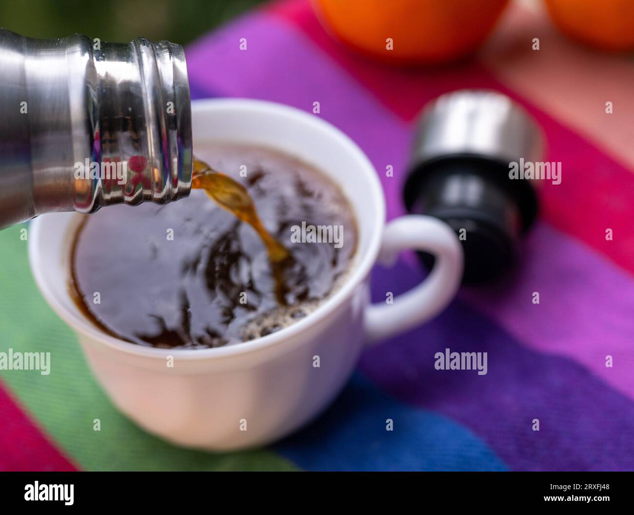 ILLUSTRATION - 17 September 2023, Berlin: Warm coffee flows from a thermos flask into a cup standing on a picnic blanket. (to dpa: 'The thermos flask and the somewhat hapless history of its inventor ') Photo: Monika Skolimowska/dpa Stock Photo