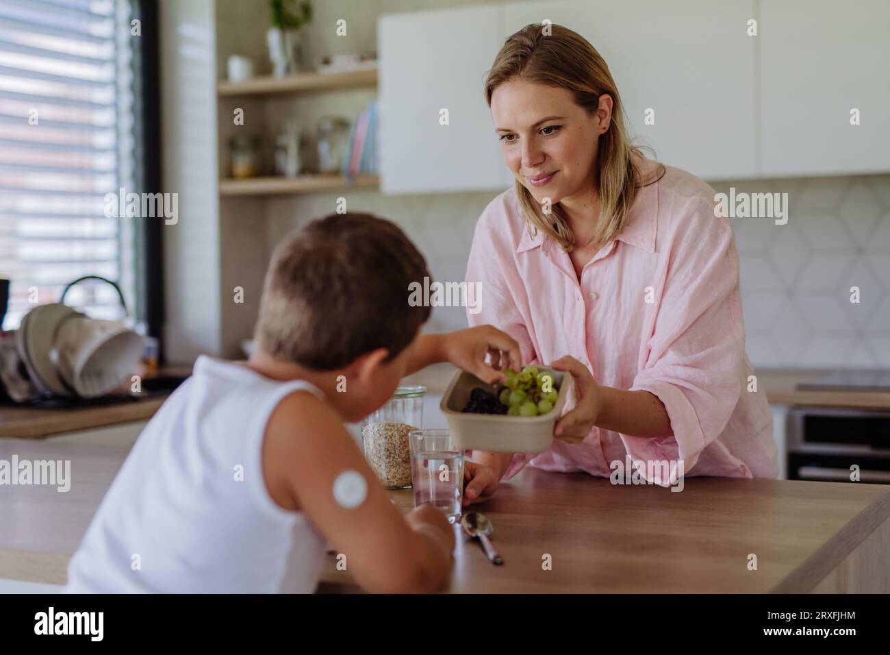 Diabetic boy with a continuous glucose monitor is careful with his diet