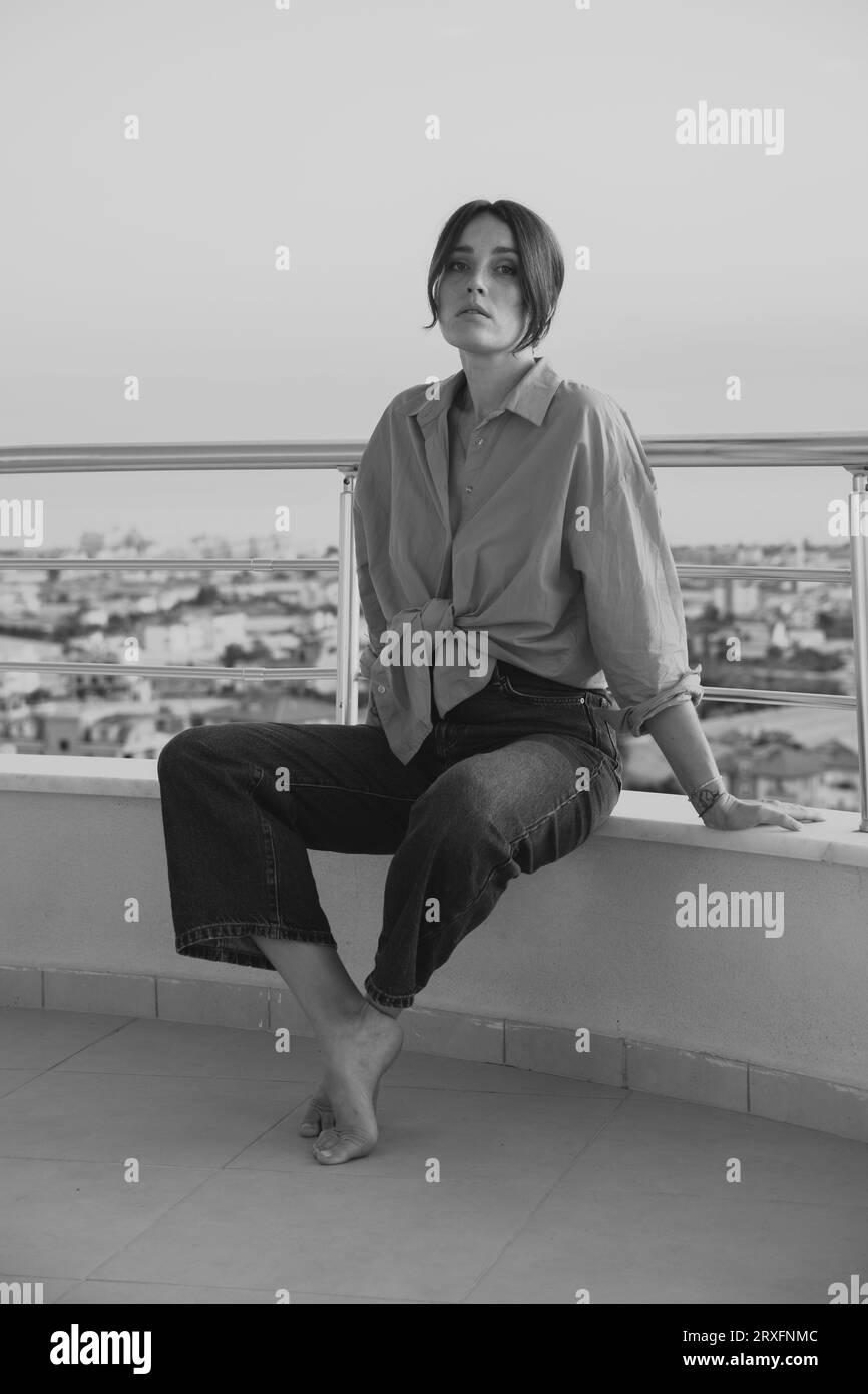 Beautiful girl on the balcony overlooking the sea. A girl in a red