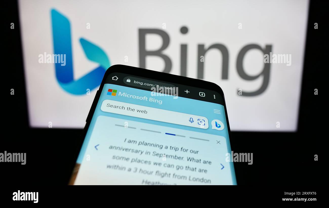 Smartphone with webpage of web search engine Microsoft Bing on screen in front of business logo. Focus on top-left of phone display. Stock Photo