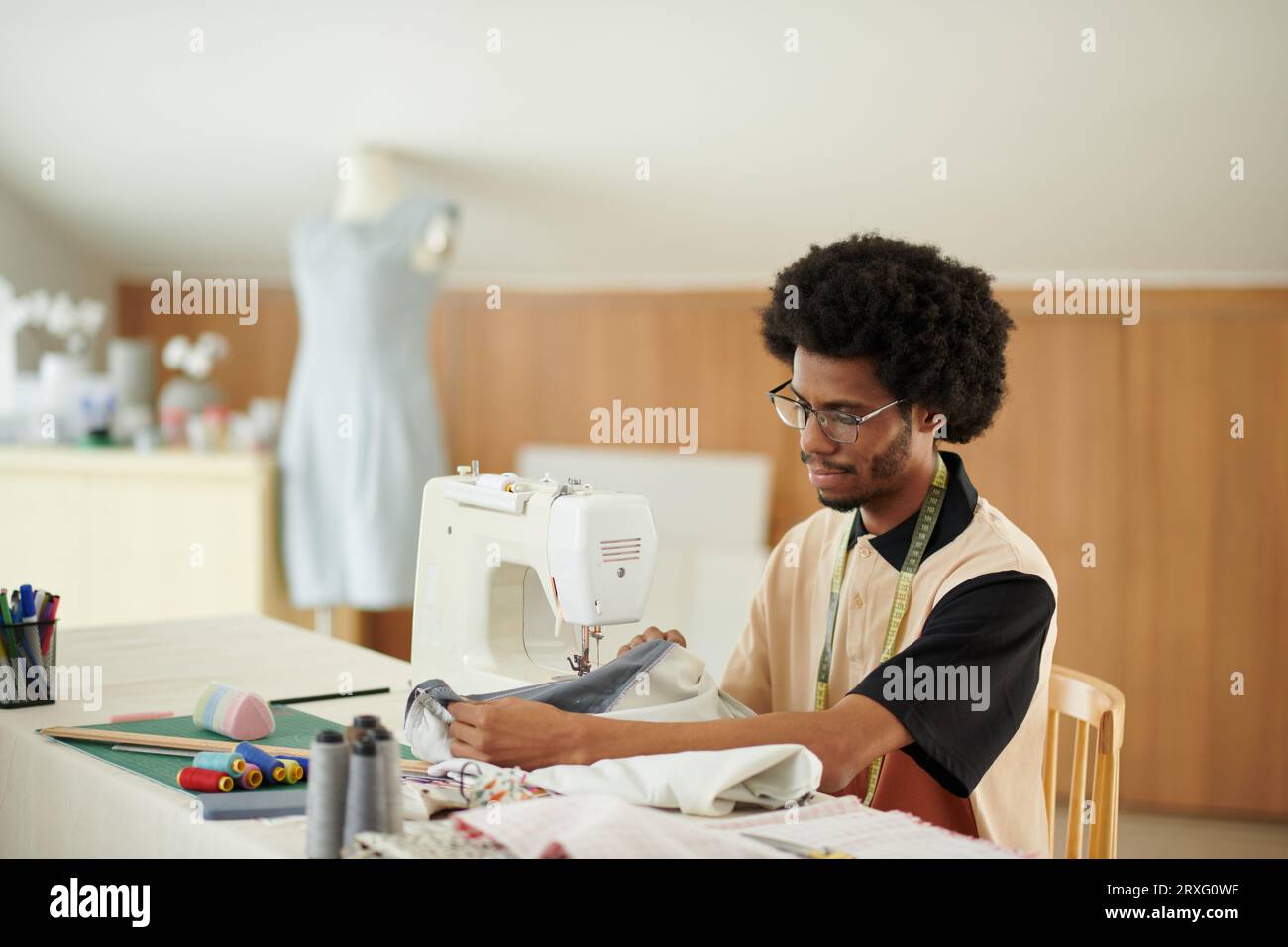 Tailor working on bespoke dress for client Stock Photo