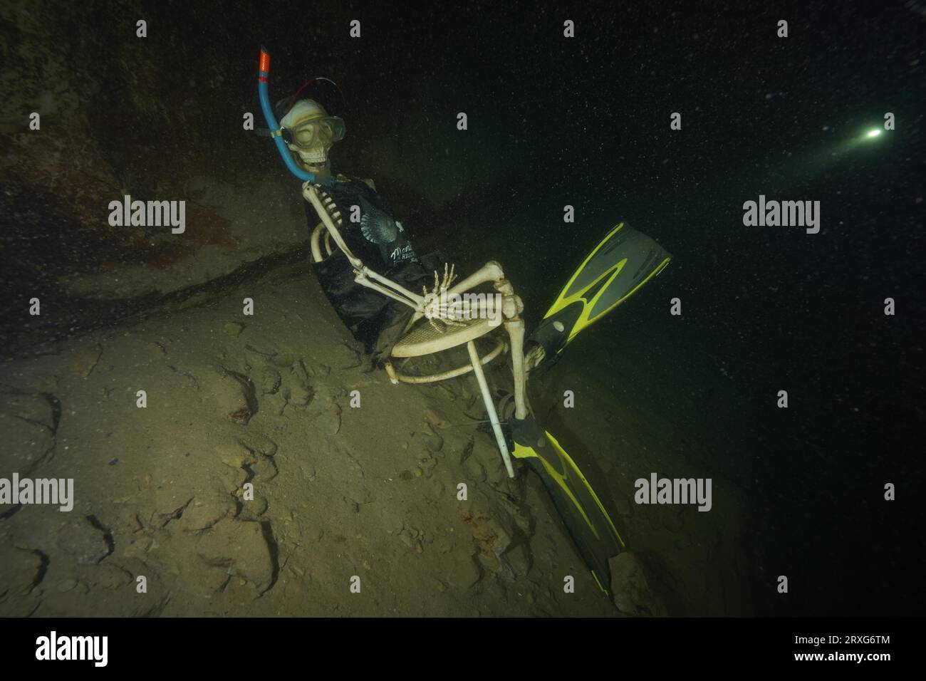 Oskar, the skeleton, sits on his chair on the lake bottom, equipped