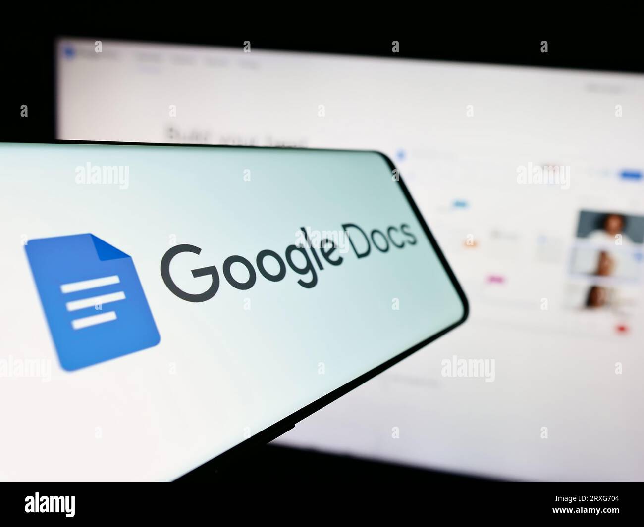 Mobile phone with logo of online word processing product Google Docs on screen in front of website. Focus on center-left of phone display. Stock Photo