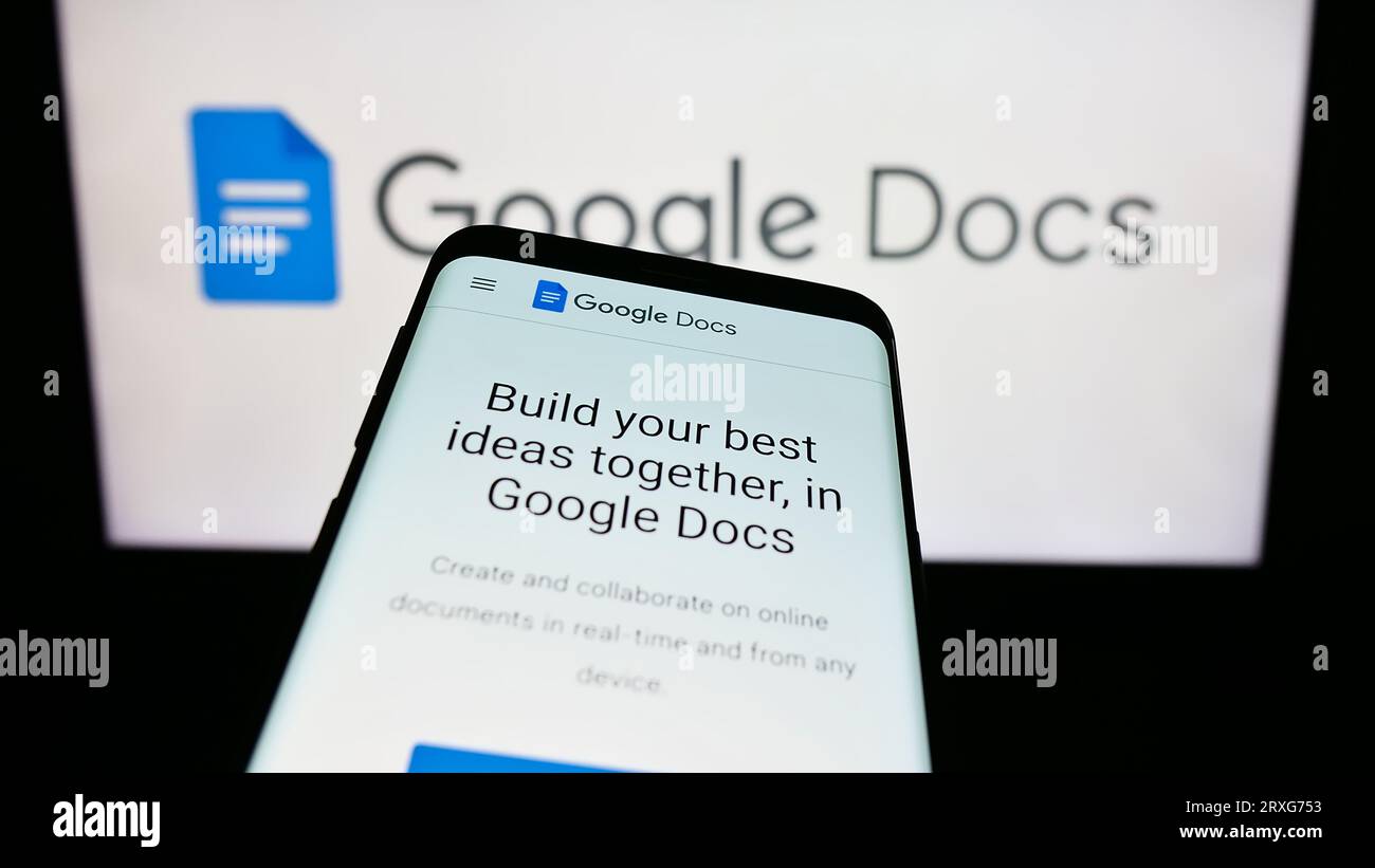 Smartphone with website of online word processing product Google Docs on screen in front of business logo. Focus on top-left of phone display. Stock Photo