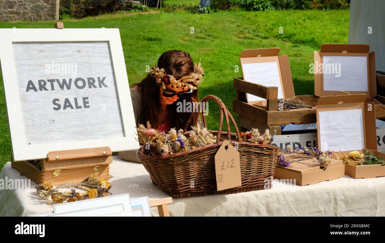 Stall holder selling dried flowers and artwork at a country fete, Cornwall, UK - John Gollop Stock Photo