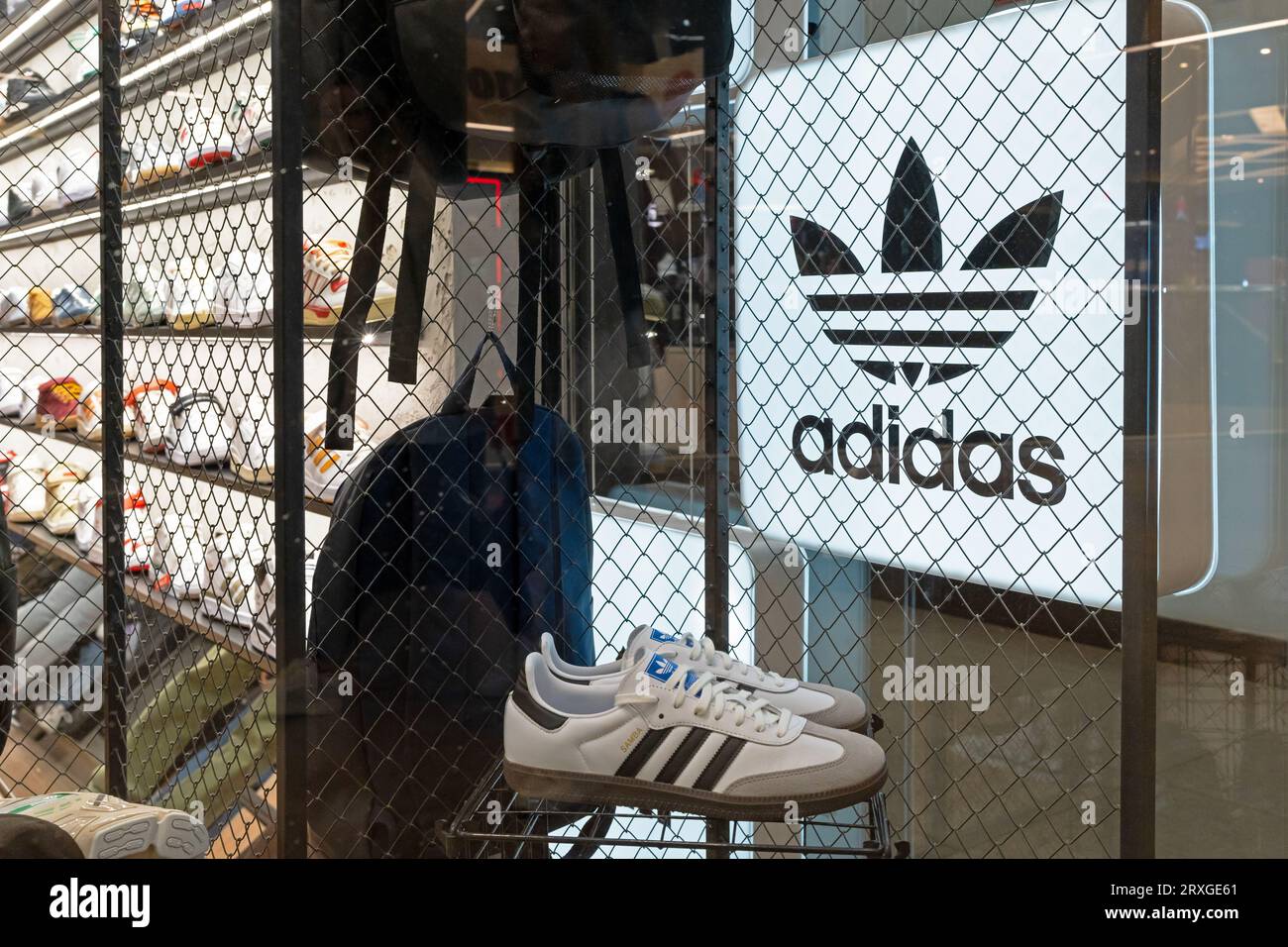 Adidas brand advertising sign and sneakers in the interior of a shoe store. Adidas neon store sign in shop window. Minsk, Belarus, September 18, 2023 Stock Photo